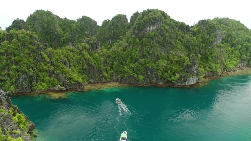 Aerial view of boats driving towards the shore