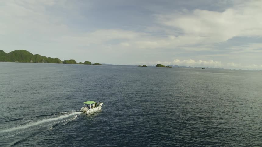 An aerial view of a boat sailing on a lake