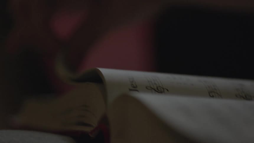 A woman turns the page of a book
