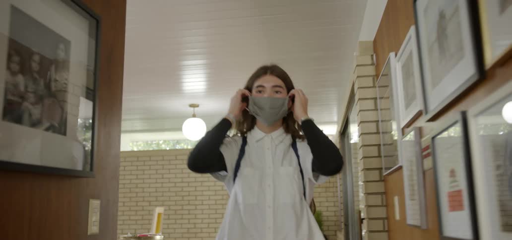 Woman grabbing a mask off a table and walking towards something