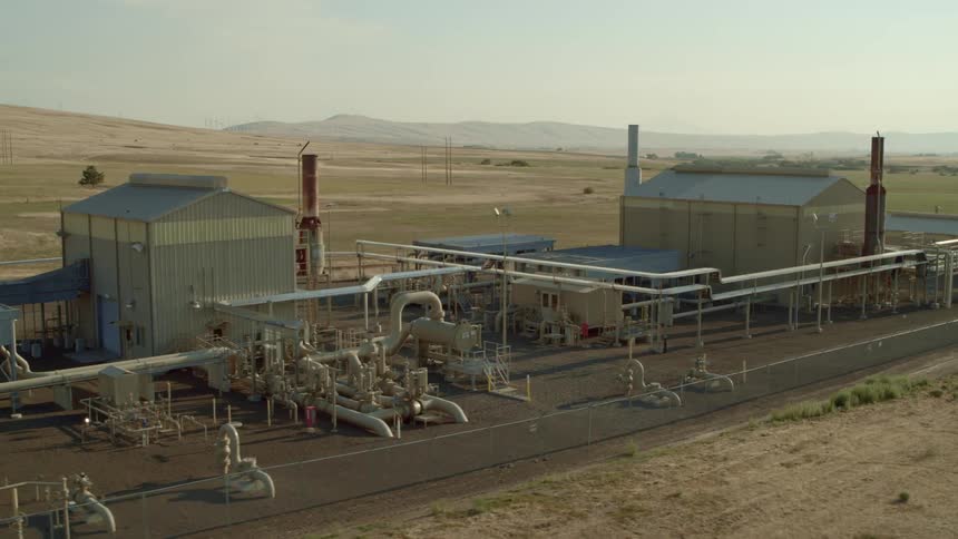 Orbiting around a rural natural gas compressor facility set along rolling hills