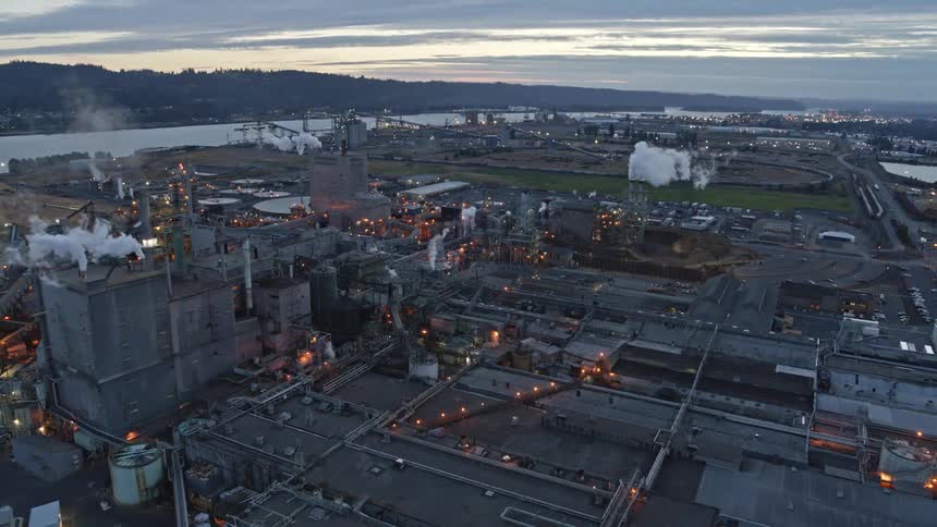 Wide pullback reveal of a vast industrial landscape at dusk