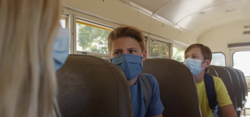 Group of children sitting on a bus talking to each other