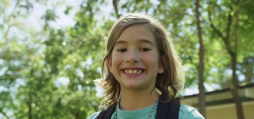 Young boy smiling towards a camera