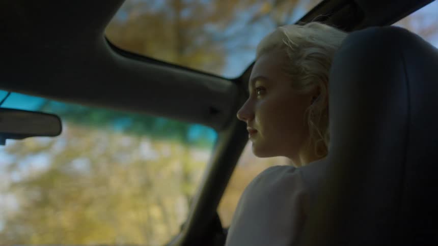 A woman is driving in a car during the day