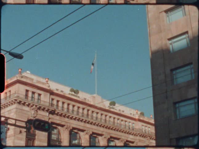 Flag waving at the top of a building in a city