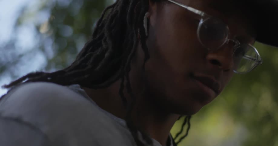 A teenage boy moves his head to a beat as she listens to music