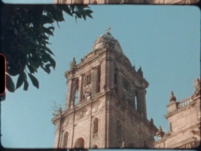 The tall bell tower has a cross at the top