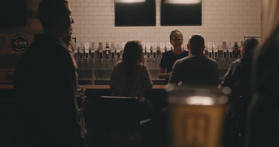 Bartender talking to customers sitting at a bar