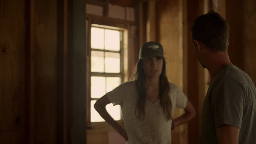 A man and a woman are discussing ideas inside a home thats being renovated
