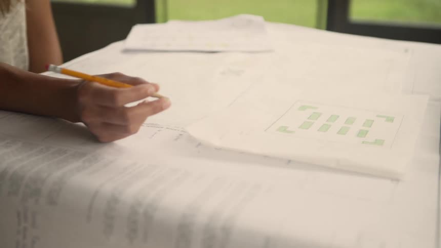An architect is looking at blueprints in the office