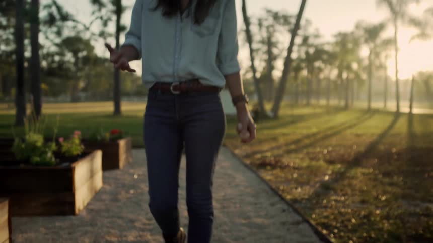 A woman is walking outdoors at dusk