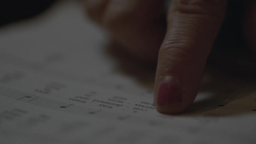 A hand is tracing some writing on a page