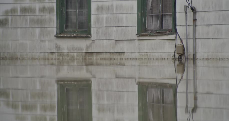 Flood water outside of a tattered old building