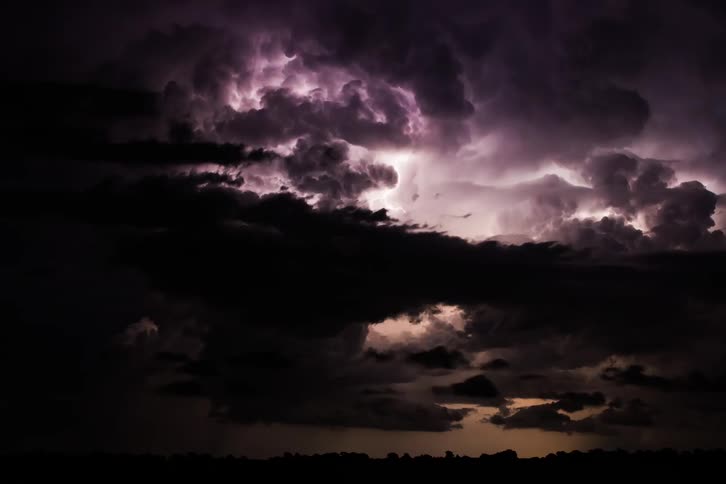 Lightning flashing in storm clouds in the dark