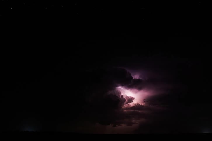 Storm clouds filled with lightning flashing violently across the sky