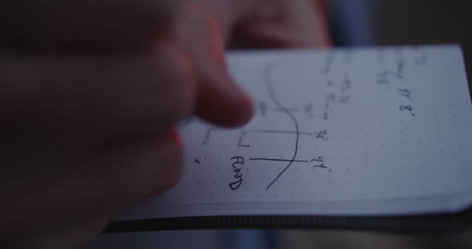 A person is writing in a notebook