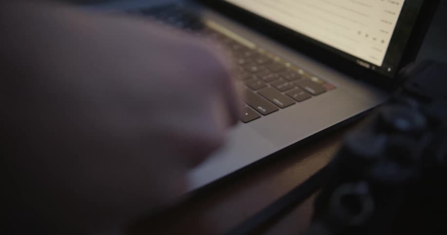 A man takes a memory card out of a camera and puts it in his laptop