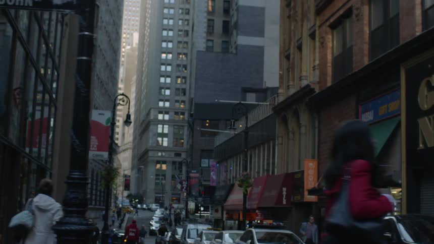 Cars parked and people walking down streets in large city