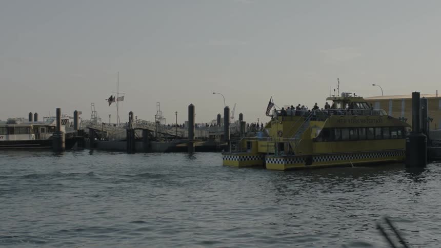 A ferry full of people is docked near a pier