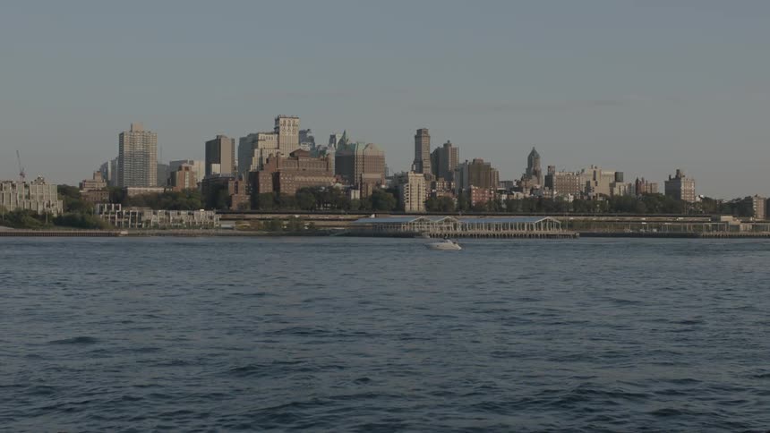 A large body of water flows in front of city buildings