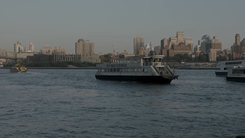A ferry boat turns around and approaches a dock in a harbor