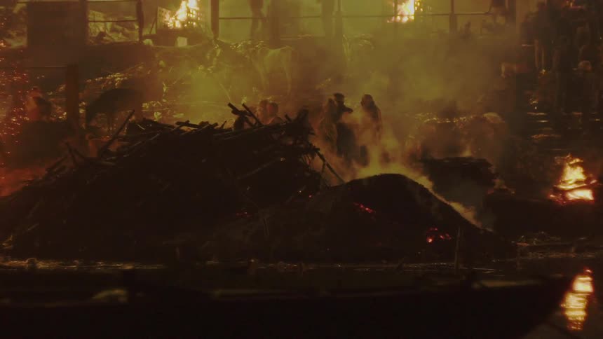 People stand in front of the area that is destroyed