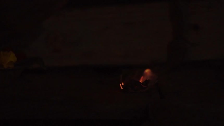 Small flame on a piece of paper then put out by a hand