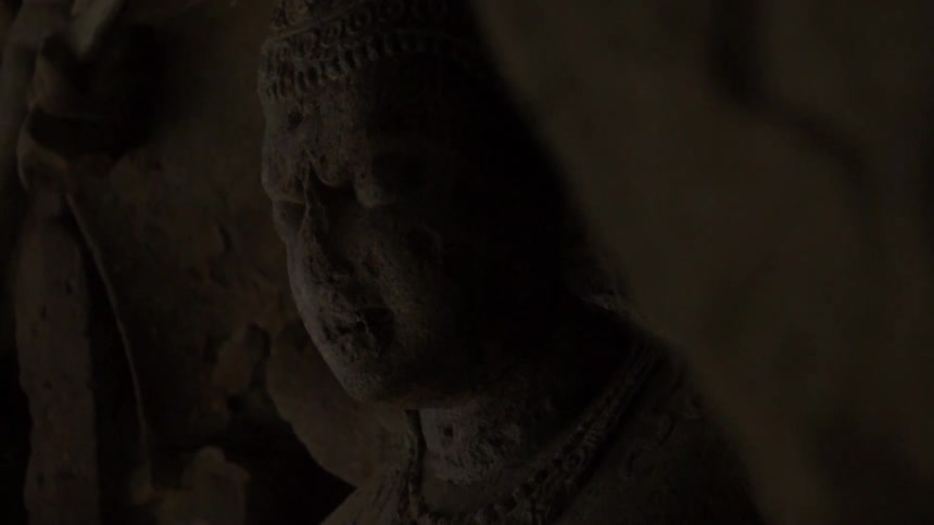 Close up of a stone statue in a dark room