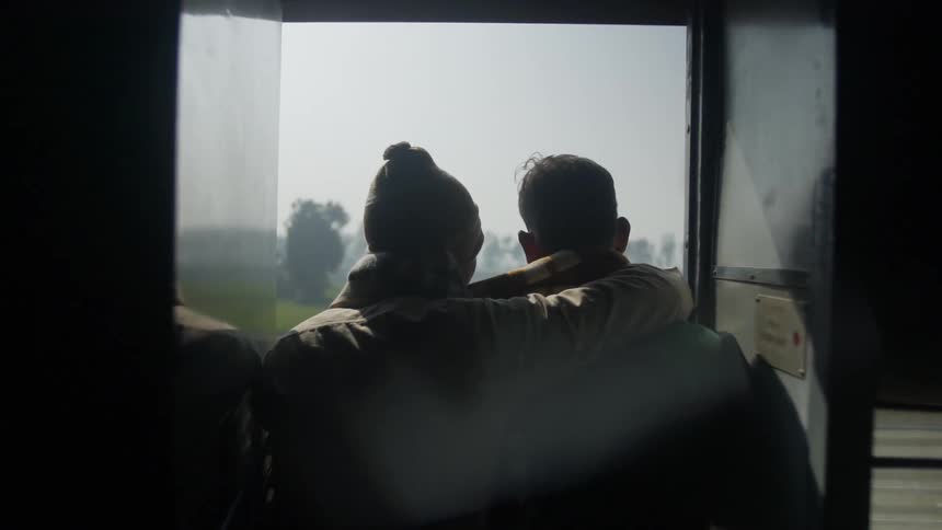 Humans hugging over the shoulder on a train