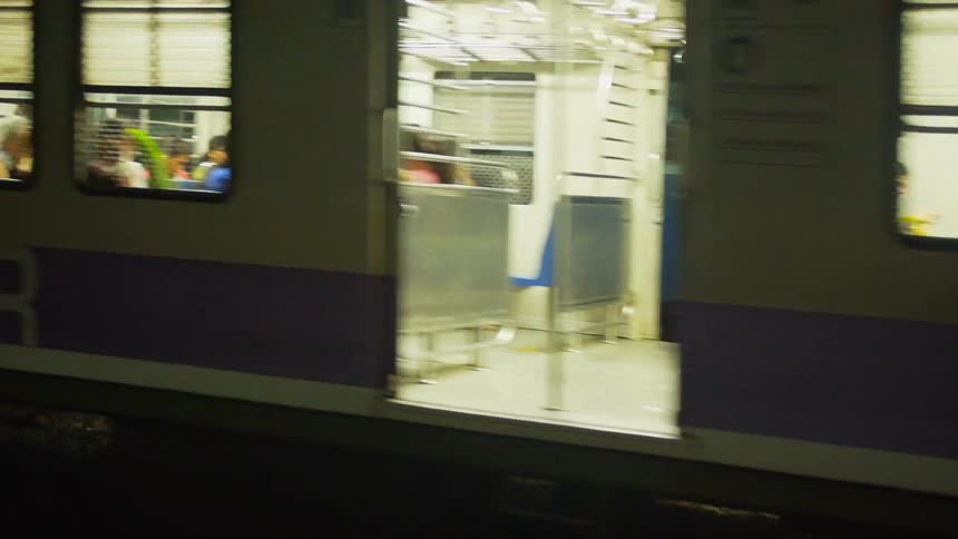 A subway train moves on the trail holding a large group of riders