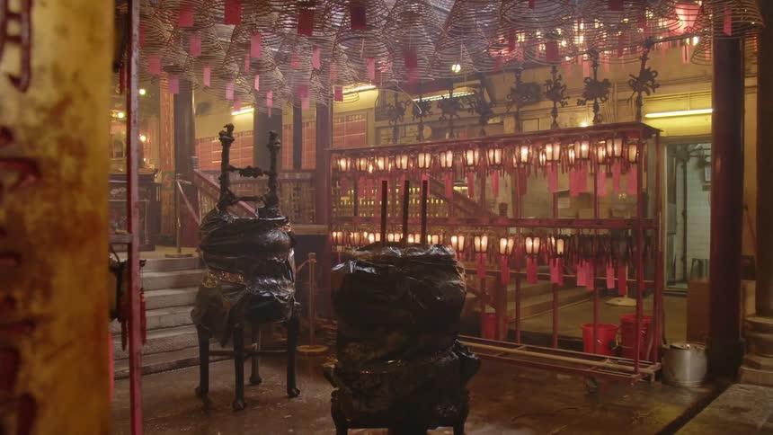 Interior of an asian temple with lanterns an altar tags and chinese writing