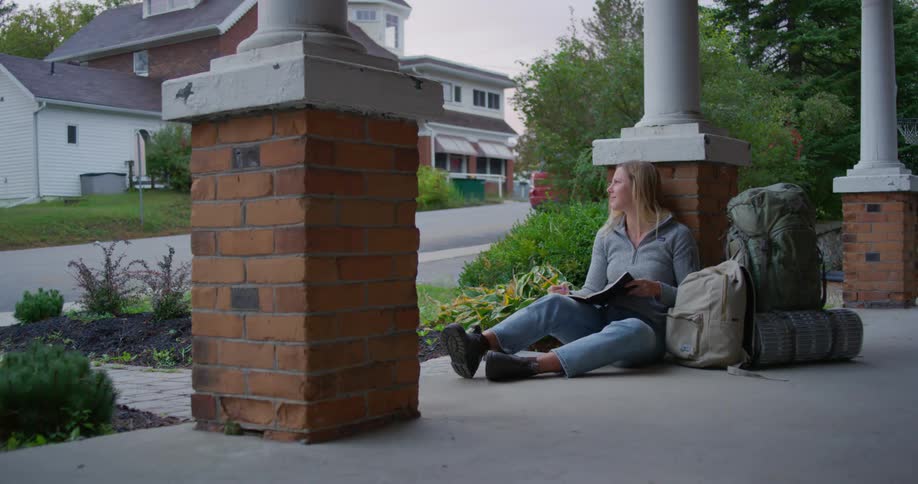 A woman sits on porch and reads