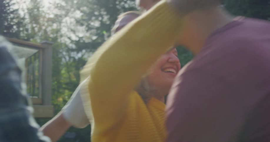 Mom greets her sons arrival in the backyard with hugs and smiles in the daytime