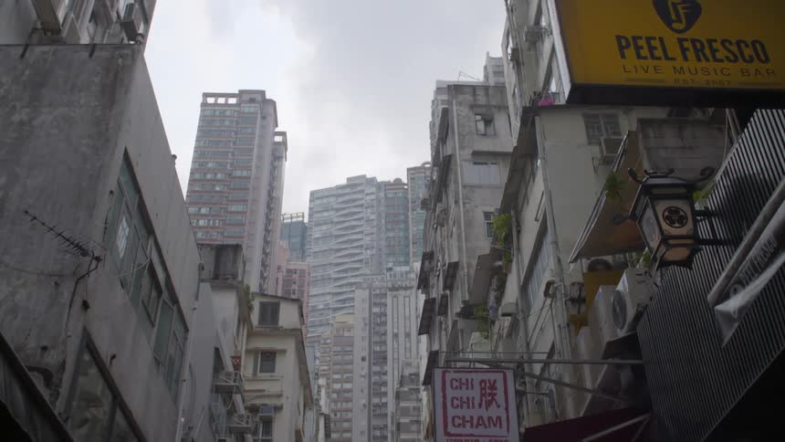 Store fronts fill a city block and lead to downtown skyscrapers