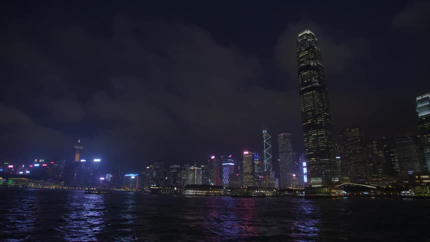 Landscape view of a person on a boat on the water with the city skyline