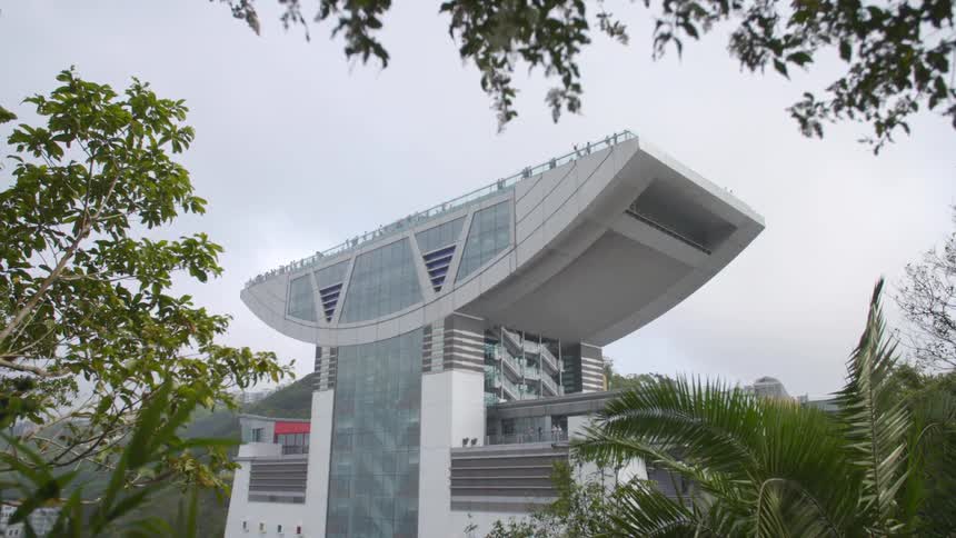 Large modern office building in a city next to some mountains