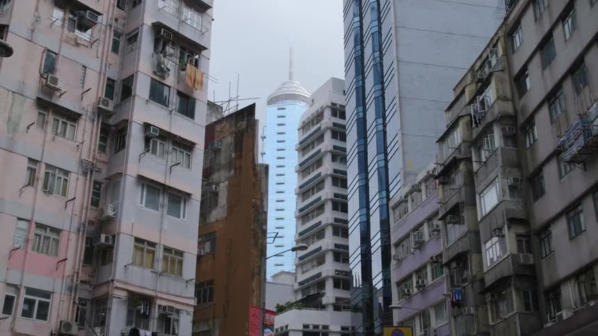Run down apartment buildings sit near modern skyscrapers in a city