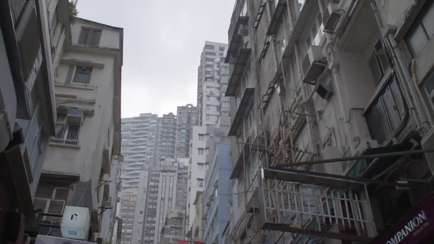 A city with buildings and signs with the sky and clouds above