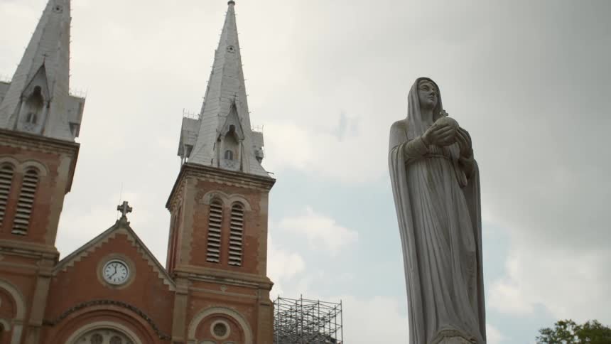 Statue of a woman in front of a church