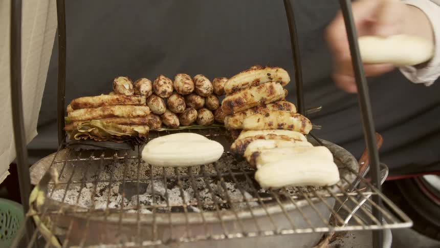 Person putting banana pieces on a grill