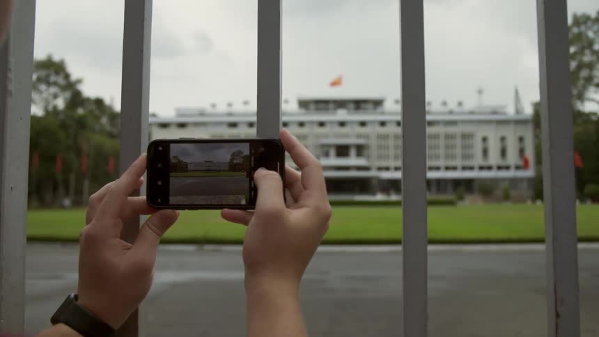 A person with a smart phone taking a picture of a building