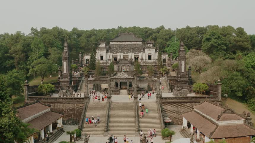 Crowds of people walking around outside of a historic building