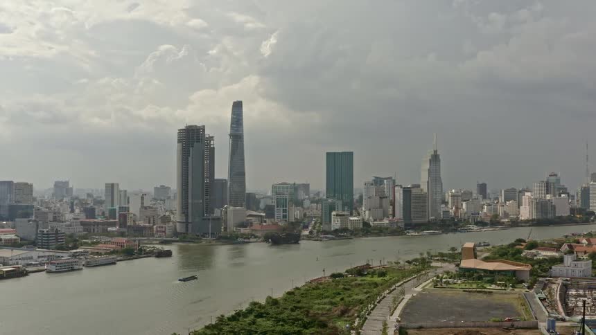 A city with a river buildings and skyscrapers with the sky and clouds in the background