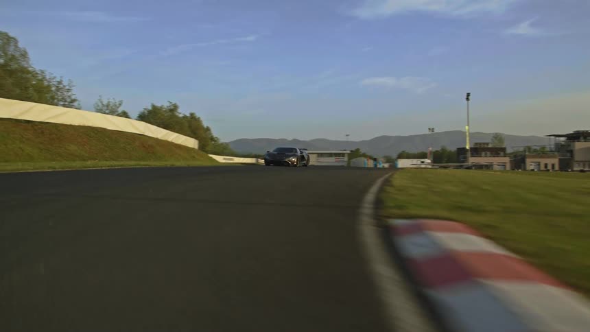 A sports car races along an outdoor track