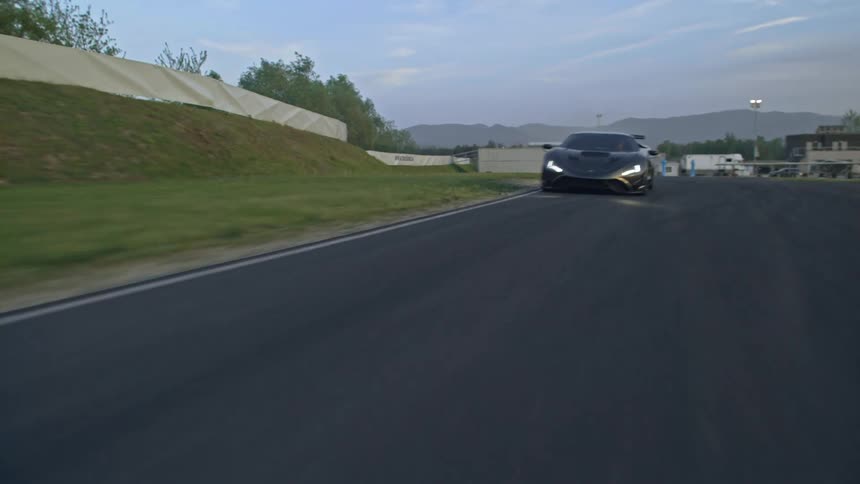 A black sports car races down a curved track