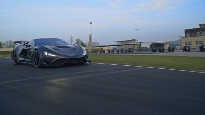 A car is driving on a racetrack road