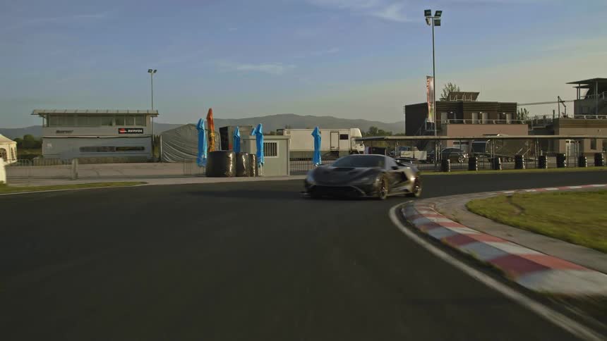 Black sports car driving on a race track at daytime