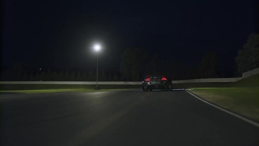 A car is driving on a road at night
