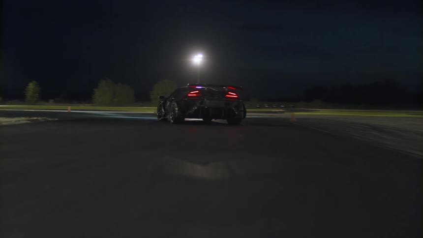 A car is driving on a road at night